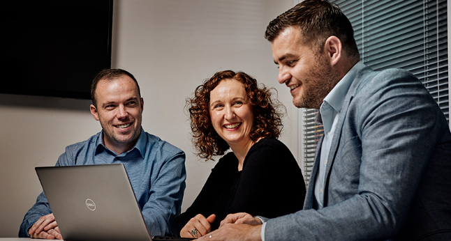 Experts laughing over a laptop screen